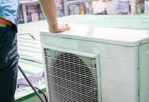condenseren eenheid van een lucht conditioner Aan vervagen technicus sproeien water. lucht conditioner schoonmaak door een Mens. lucht conditioner onderhoud onderhoud Bij huis of kantoor. arbeider werken voor ac onderhoud. foto