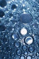 abstract licht blauw achtergrond met olie cirkels . bubbels van water dichtbij omhoog . olie bubbels in de water macro. cirkel bubbels achtergrond foto