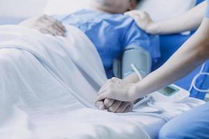kant visie van verschillend artsen onderzoeken Aziatisch vrouw geduldig in bed in afdeling Bij ziekenhuis. foto