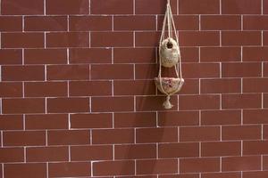 handgemaakt vogelstand nest zijn hangende Aan de bakstenen muur. interieur decoratie ontwerp. nest gemaakt van vezel. foto