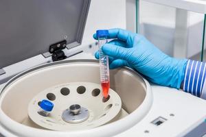 wetenschapper invoegen een buis in een laboratorium centrifuge foto