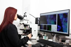 jong vrouw wetenschapper analyseren menselijk chromosomen gebruik makend van de fluorescentie in situ hybridisatie techniek foto