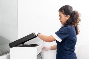 jong vrouw wetenschapper gebruik makend van een centrifuge in de laboratorium. foto