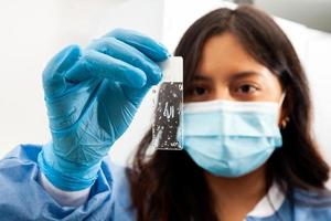 jong vrouw wetenschapper op zoek Bij een glijbaan van ontparaffineerd zakdoek monsters in de laboratorium. op xyleen gebaseerd verwijdering van paraffine. foto