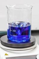 glas beker Aan top van een magnetisch laboratorium roerder foto