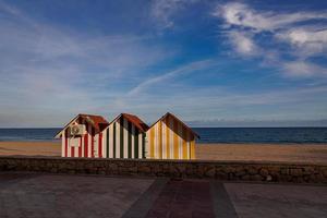 vredig kust landschap met drie kleurrijk houten huizen strand en vakantie foto