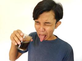 Aziatisch Mens drinken een schot van bitter espresso koffie foto