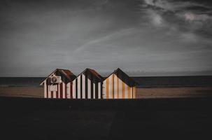 vredig kust landschap met drie kleurrijk houten huizen strand en vakantie foto