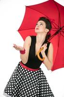 retro meisje met rood paraplu kijken het weer. foto