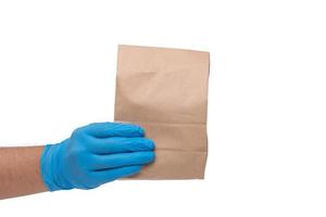dichtbij omhoog hand- in medisch handschoen en Holding voedsel papier zak Aan wit achtergrond geïsoleerd achtergrond. concept van bestellen voedsel online en levering onderhoud. foto