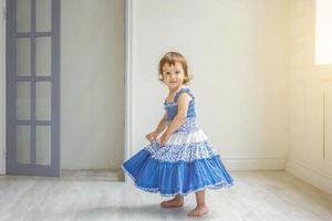 weinig meisje dansen in helder licht leven kamer Bij huis en lachend foto