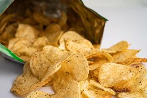 aardappel chips, heerlijk pittig voor crips, dun plak diep gebakken tussendoortje snel voedsel in Open tas. foto