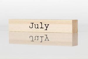 houten kubus met de opschrift juli Aan een wit achtergrond foto
