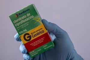 rio, Brazilië - januari 27, 2023, hand- met beschermend rubber handschoen Holding geneeskunde doos, citofloxacine hydrochloride foto