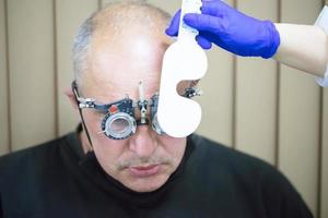 optometrist picks omhoog bril voor de geduldig. foto