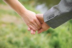 een Mens houdt een vrouw hand. handen van de bruid en bruidegom met een verloving ring detailopname foto