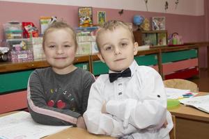 een jongen en een meisje van kleuterschool kijken Bij de camera. foto