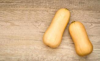 vlak leggen of top visie butternut squash of butternut pompoen gramma Aan hout tafel keuken achtergrond. winter herfst groente voedsel foto