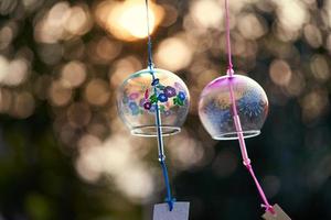 concept van liefde overgebracht door twee Japans traditioneel wind klok of furin klokkenspel Aan bokeh achtergrond foto