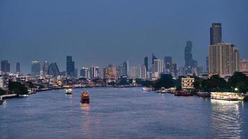 nacht Bangkok, stadsgezicht gebouw met rivier- en boot achtergrond. horizon foto