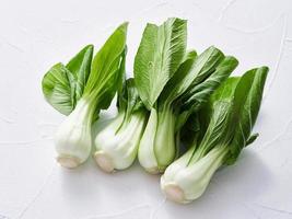 stapel van baby bok choy of pak choy Aan wit tafel voedsel keuken achtergrond. hoop van bok kies. groen bok choy foto