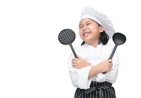 gelukkig Aziatisch meisje chef Holding Koken gereedschap foto