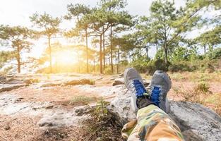 Mens voeten in sportschoenen ontspannende Aan de rots foto