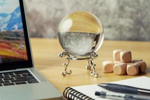 dichtbij omhoog waarzeggen of voorspelling bedrijf markten met een kristal bal Aan bureau achtergrond en kopiëren ruimte. voorspellen, laptop, waarschijnlijkheid foto