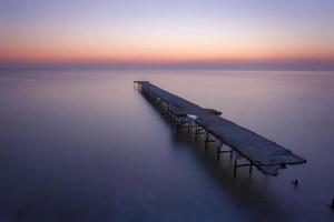 mooi zee zonsopkomst met de gebroken brug. foto