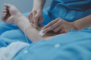 gewond geduldig tonen dokter gebroken pols en arm met verband in ziekenhuis kantoor of noodgeval kamer. verstuiking, spanning breuk of herhalende spanning letsel in hand. verpleegster helpen klant. eerste hulp. foto