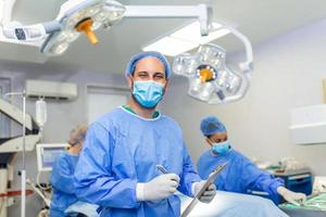 chirurg schrijven Aan klembord in operatie kamer, anesthesist schrijven de updates foto