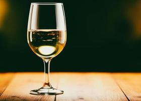 wijnglas van wit wijn Aan een houten tafel in een restaurant foto