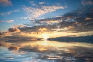 kleurrijke bewolkte zonsondergang over een watermassa foto