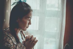 een vrouw bidt met haar ogen dicht. foto