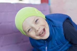 portret van een vrolijk kleuter jongen in een groen hoed. foto