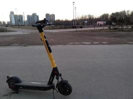 Sankt petersburg Rusland - 04 13 2023 elektrisch scooter Aan achtergrond park en wolkenkrabbers . voorjaar reizen en vrije tijd foto