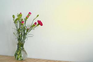 boeket van roze bloemen in een vaas Aan een licht achtergrond. anjers. foto