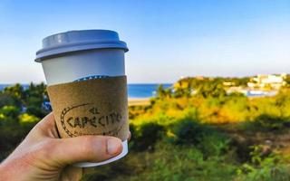 puerto escondido oaxaca Mexico 2023 koffie naar Gaan mok Aan de strand zand zee golven. foto