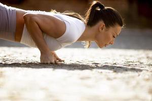mooie jonge vrouw doet push-ups op straat foto