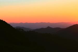 zonsondergang in lucht en wolk, mooi kleurrijk schemering tijd met silhouet van berg. foto