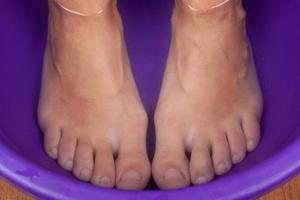 voeten in warm water, voetenbad close-up.