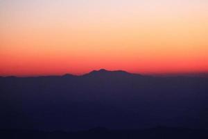 zonsondergang in lucht en wolk, mooi kleurrijk schemering tijd met silhouet van berg. foto