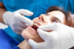 mooi vrouw ontvangen een orthodontisch behandeling Bij tandarts kantoor foto