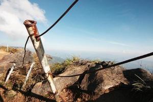metaal barricade en berg barrière voor veiligheid in leven van een ongeluk Aan de klif en waarschuwing teken etiket in Thais tekens schreef dat gemeen Gevaar zone Aan heuvel in Thailand foto