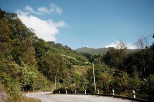 geel teken etiket waarschuwing van kromme weg Aan de berg in Thailand foto