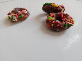dichtbij omhoog van geglazuurd donuts met helder gekleurde hagelslag, geïsoleerd Aan een wit achtergrond. foto
