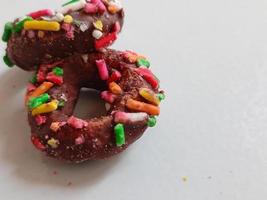 dichtbij omhoog van geglazuurd donuts met helder gekleurde hagelslag, geïsoleerd Aan een wit achtergrond. foto