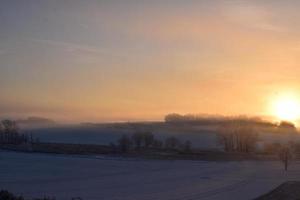 oranje zonsopkomst bovenstaand sneeuw gedekt landschap foto