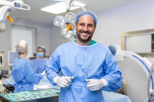 portret van mannetje chirurg in operatie theater op zoek Bij camera. dokter in scrubs en medisch masker in modern ziekenhuis in werking kamer. foto