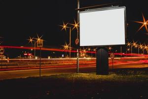 leeg reclamebord met wazig verkeerslichten 's nachts foto